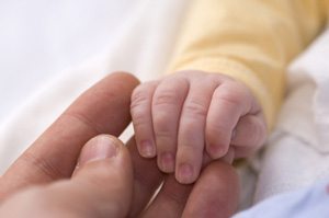 Photo of a baby holding adults hand